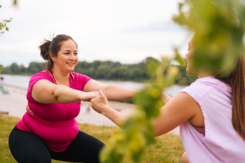Obese women exercising with other woman