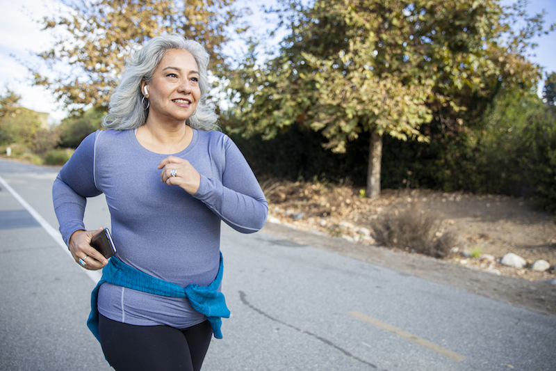 Middle aged woman with white hair jogging 
